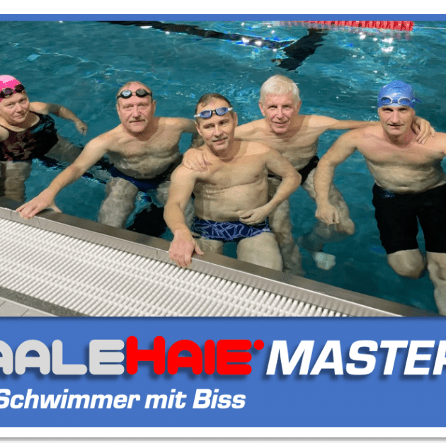 Gruppe von sechs Schwimmern am Beckenrand in einem Hallenbad, lächelnd posierend vor blauem Wasser.