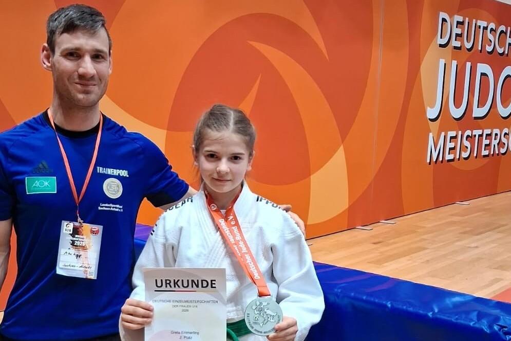 Alexander Lenkt steht neben Greta Emmerling die eine Urkunde &uuml;ber den zweiten Platz sowie eine Medaille hochh&auml;lt.