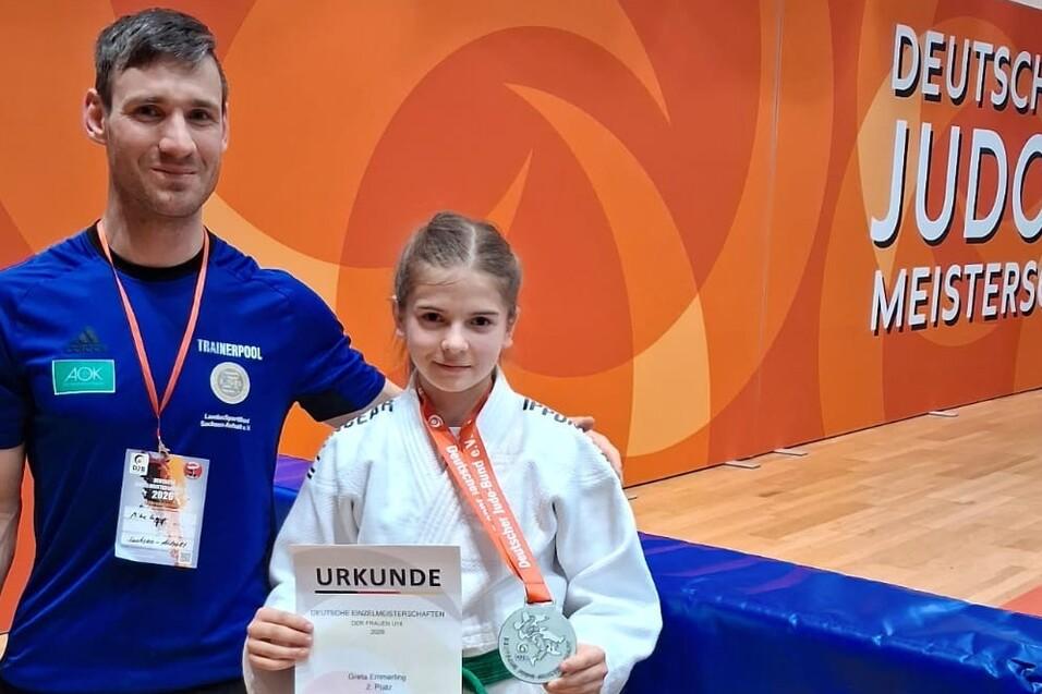 Alexander Lenkt steht neben Greta Emmerling die eine Urkunde &uuml;ber den zweiten Platz sowie eine Medaille hochh&auml;lt.