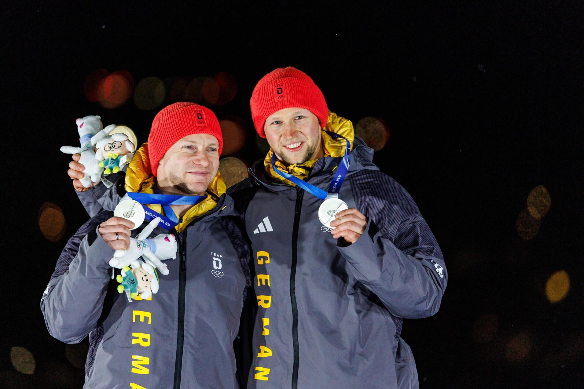 Francesco Friedrich und Alexander Sch&uuml;ller halten beide eine Silbermedaille von den Olmypischen Winterspielen 2026 hoch.