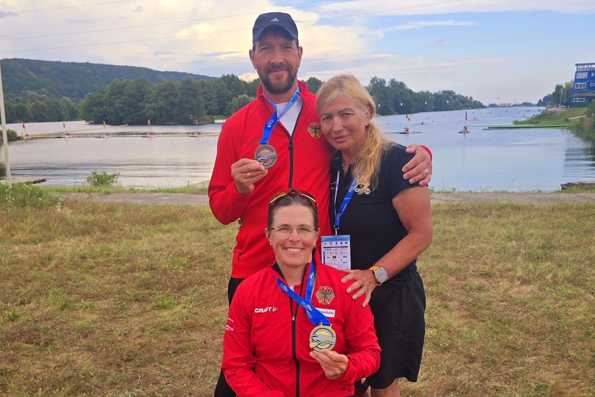 Anja Adler h&auml;lt ihre Goldmedaille und Maik Polte seine Bronzemedaille bei der EM im Marathon in Rum&auml;nien hoch. Daneben steht die Trainerin Ognyana Dusheva.