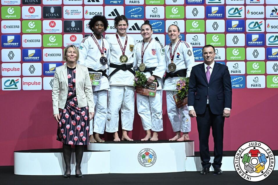Siegerfoto von Judoka mit Medaillen auf dem Podium, umgeben von Vertretern des Veranstalters und Sponsorenlogos.
