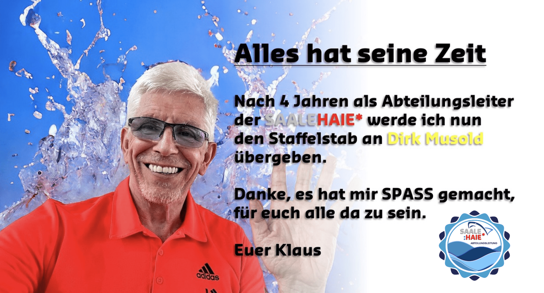 Lächelnder Mann in rotem Shirt vor spritzendem Wasser, hält eine Hand hoch und kündigt einen Führungswechsel an.