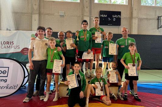 Die Ringer des SV Halle zeigen ihre Urkunden und Medaillen vom Turnier in Potsdam.