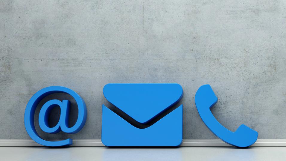 Blaue Symbole für E-Mail, Briefumschlag und Telefon auf einer grauen Wand.