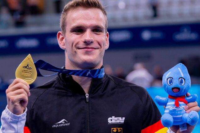 Moritz Wesemann h&auml;lt bei den Europameisterschaften im Wasserspringen die Goldmedaille und ein Maskottchen hoch.