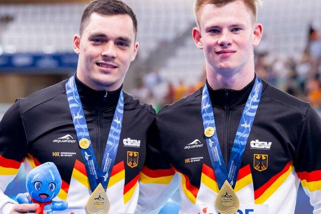 Lou Massenberger und Jonathan Schauer zeigen ihre Goldmedaille von der Europameisterschaft im Wasserspringen in Paris 2026.